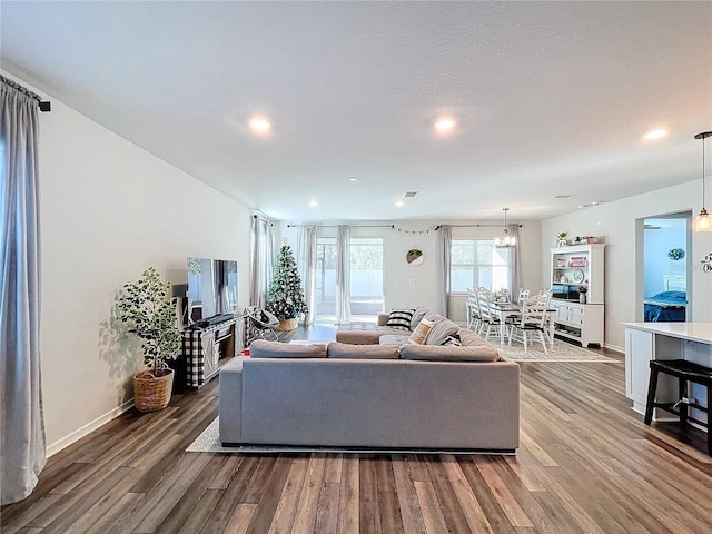 living room featuring a chandelier, wood-type flooring, and a textured ceiling