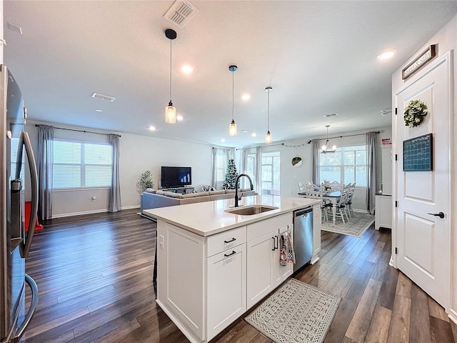 kitchen with sink, hanging light fixtures, a center island with sink, white cabinets, and appliances with stainless steel finishes