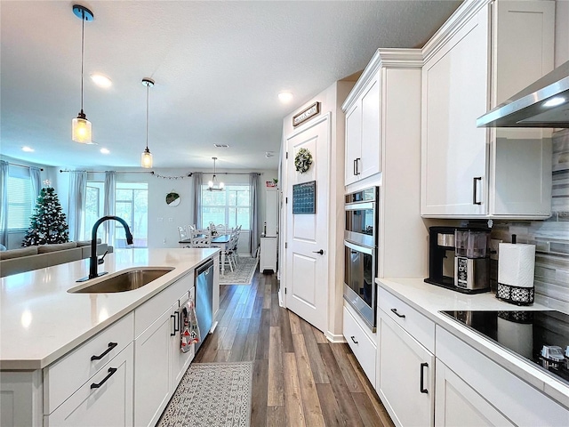 kitchen featuring pendant lighting, white cabinetry, sink, and appliances with stainless steel finishes