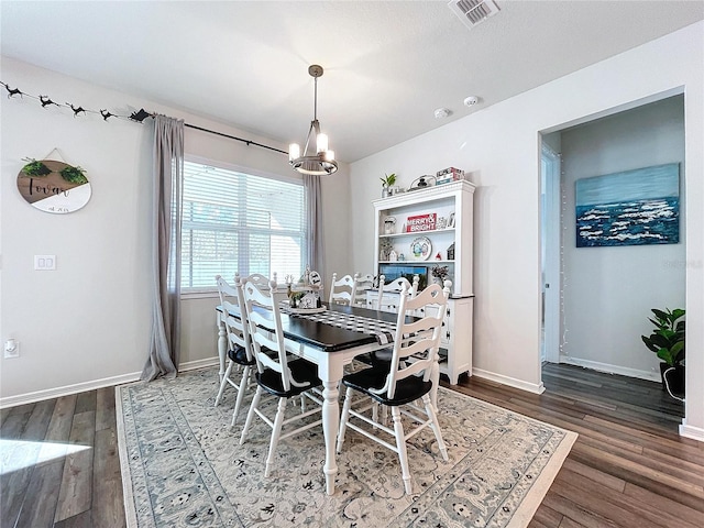 dining room with dark hardwood / wood-style flooring and a chandelier