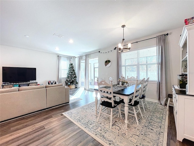 dining space featuring hardwood / wood-style floors and a chandelier