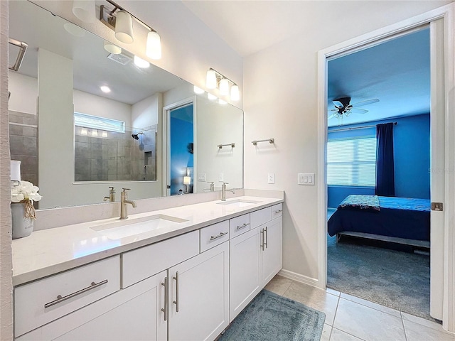 bathroom with a tile shower, a wealth of natural light, tile patterned flooring, and vanity