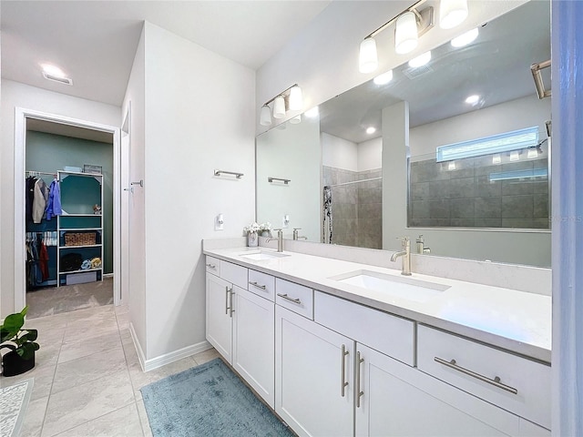 bathroom featuring tile patterned floors, vanity, and tiled shower