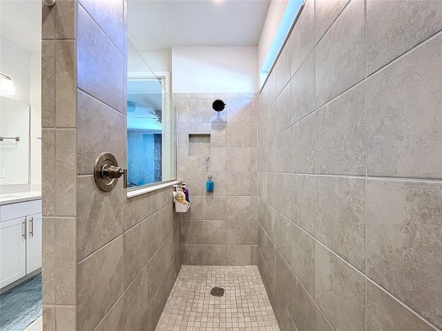 bathroom featuring a tile shower and vanity