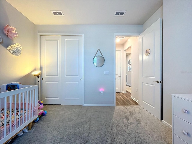 bedroom featuring a crib, carpet floors, and a closet