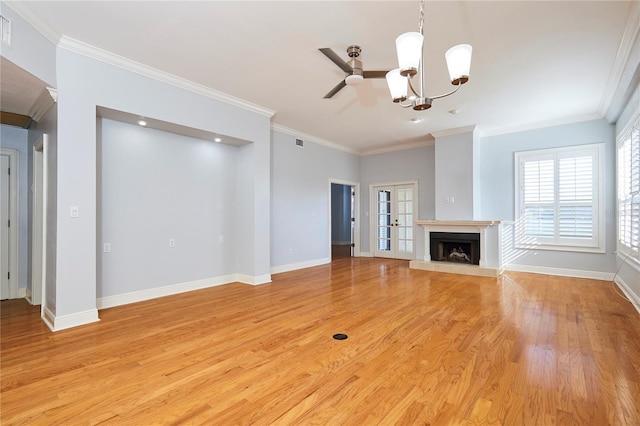 unfurnished living room with ceiling fan with notable chandelier, light wood-type flooring, and ornamental molding