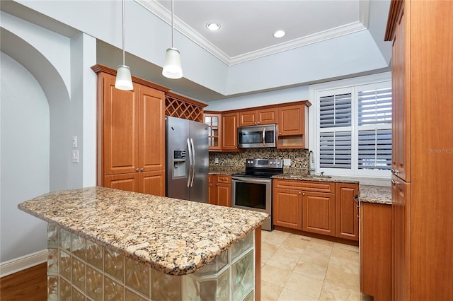 kitchen with light stone countertops, tasteful backsplash, ornamental molding, stainless steel appliances, and a center island