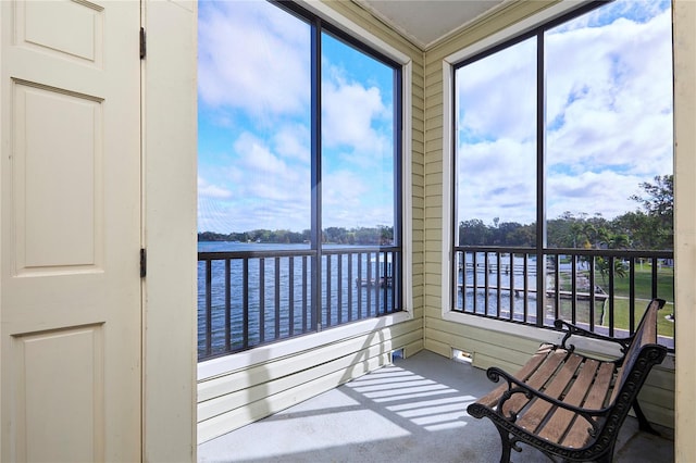 sunroom / solarium with a water view and a healthy amount of sunlight