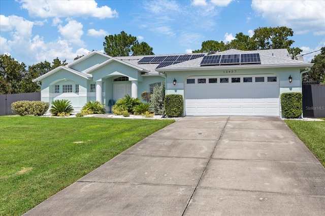 ranch-style home featuring a front lawn, a garage, and solar panels