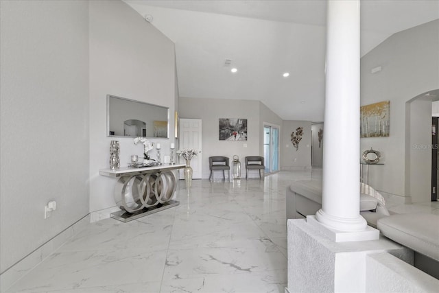 corridor with lofted ceiling and decorative columns