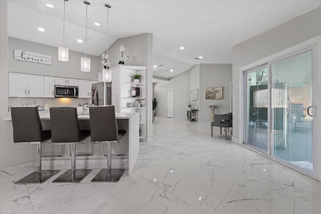 kitchen with white cabinets, stainless steel appliances, hanging light fixtures, and a healthy amount of sunlight