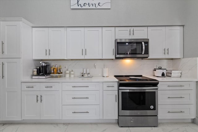 kitchen featuring white cabinets, decorative backsplash, and stainless steel appliances