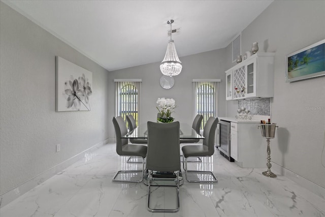 dining area featuring beverage cooler, lofted ceiling, and a notable chandelier