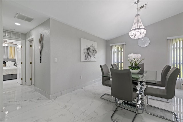 dining space with lofted ceiling and a notable chandelier