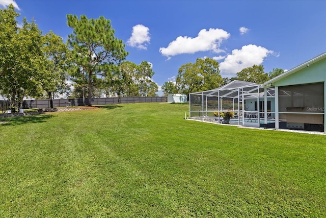 view of yard with a fenced in pool, glass enclosure, and a storage shed