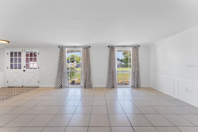 spare room featuring ornamental molding and light tile patterned flooring