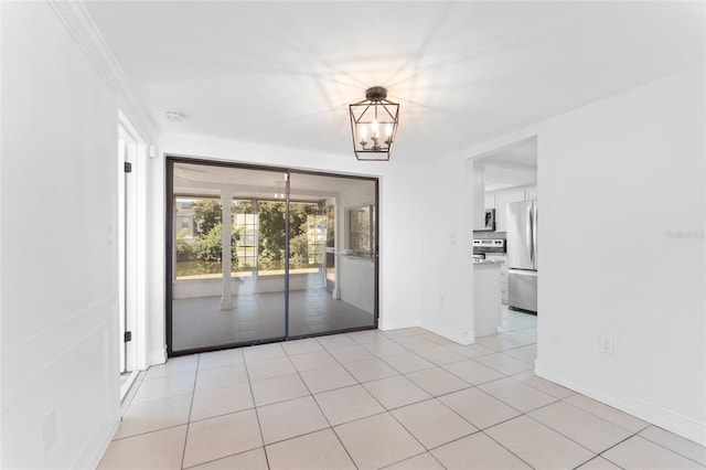 empty room with light tile patterned floors and an inviting chandelier