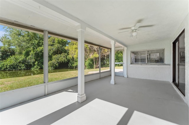 unfurnished sunroom featuring ceiling fan