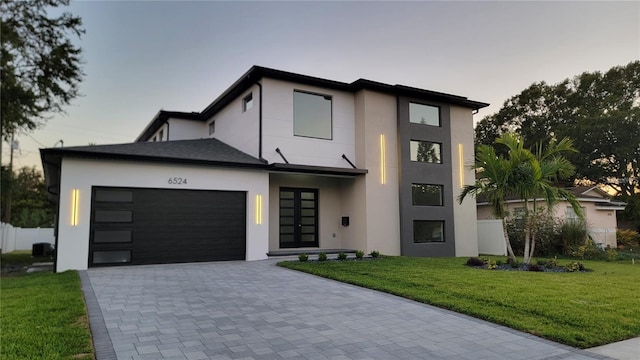 contemporary house featuring a garage and a yard