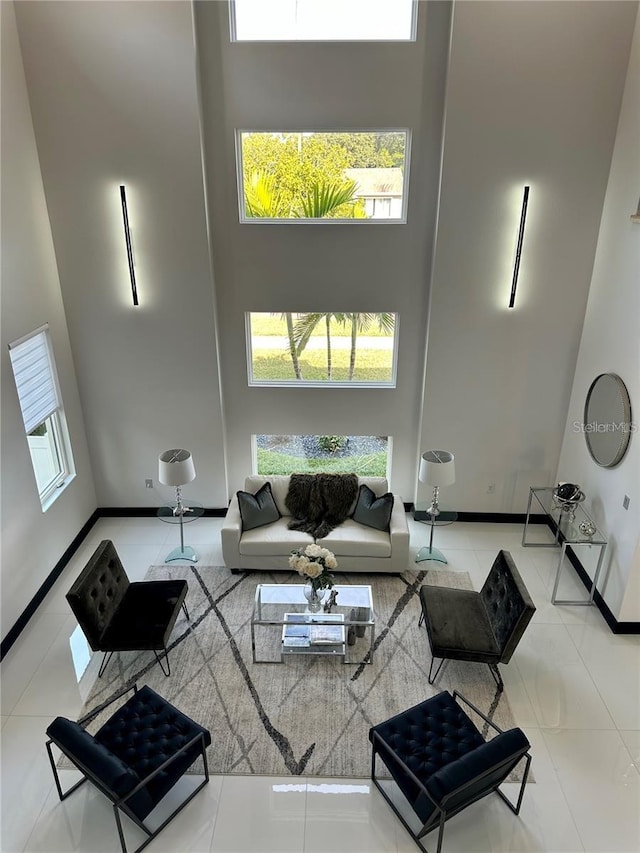 tiled living room with a healthy amount of sunlight and a high ceiling