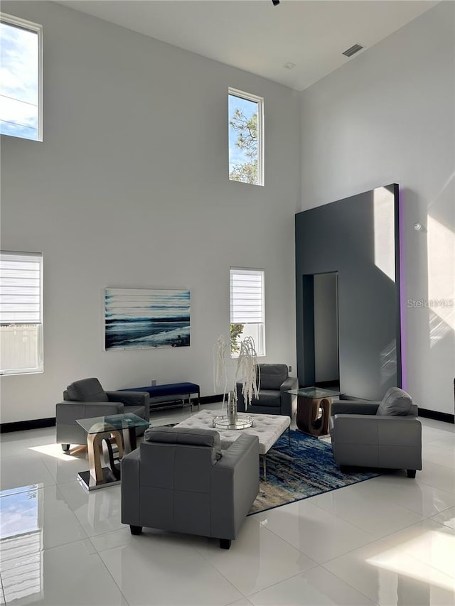 living room with a high ceiling and light tile patterned flooring