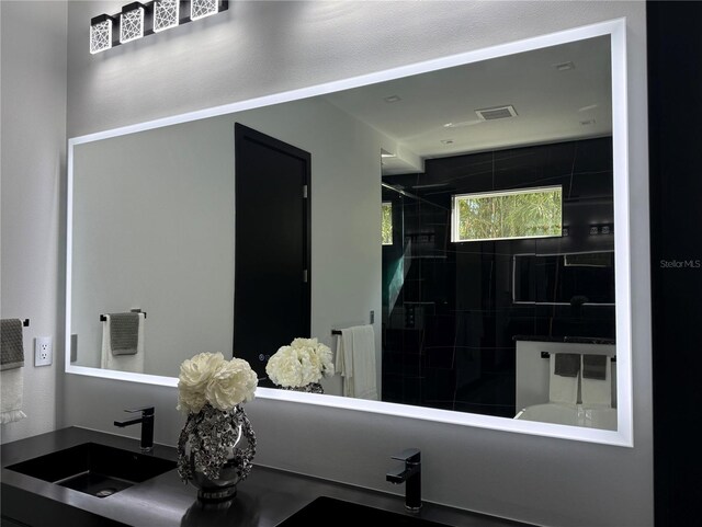 bathroom featuring sink and a tile shower