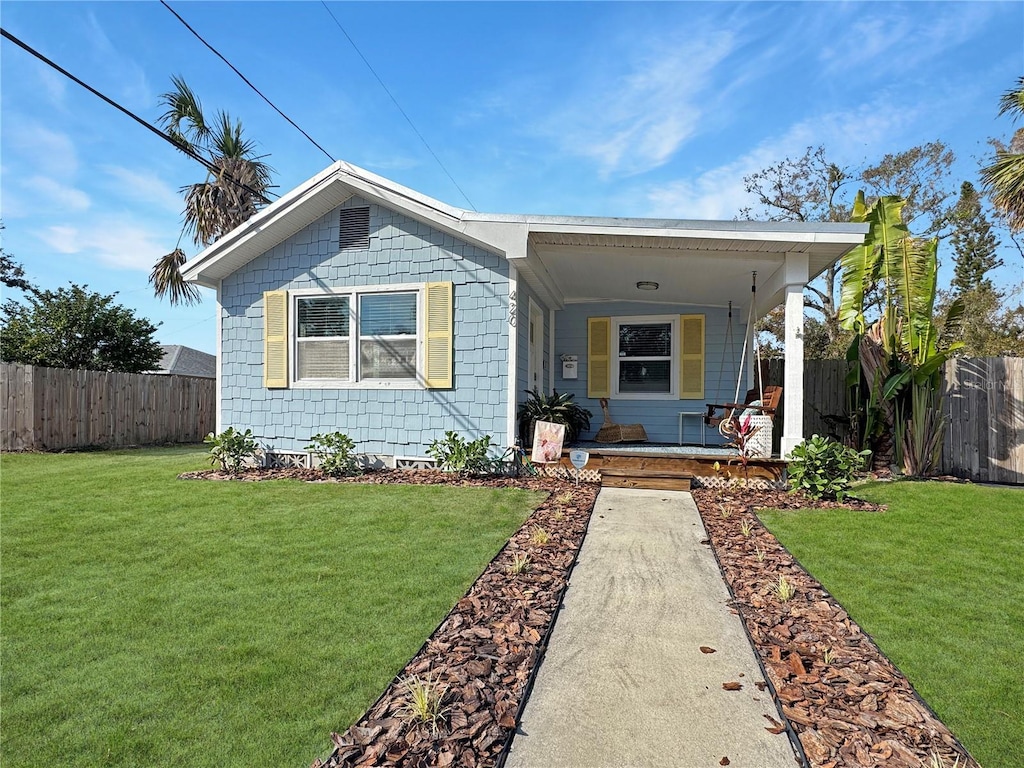 view of front of property with covered porch and a front yard