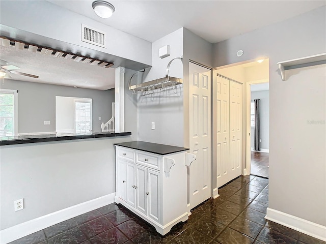 kitchen featuring white cabinets, ceiling fan, and a textured ceiling