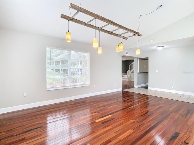 unfurnished living room with wood-type flooring and lofted ceiling