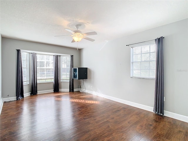 unfurnished living room featuring dark hardwood / wood-style flooring and ceiling fan