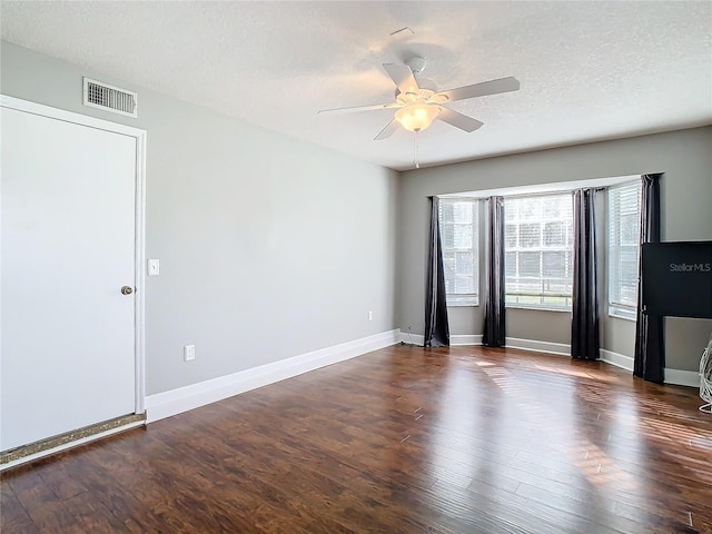 empty room featuring ceiling fan, dark hardwood / wood-style flooring, and a textured ceiling