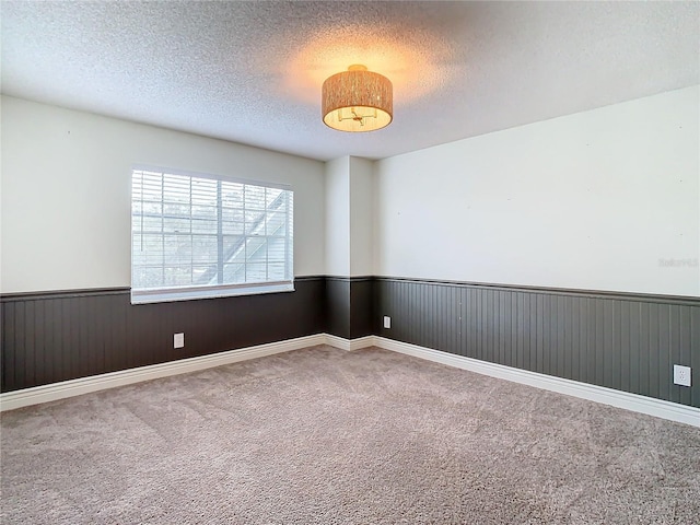 carpeted spare room featuring a textured ceiling