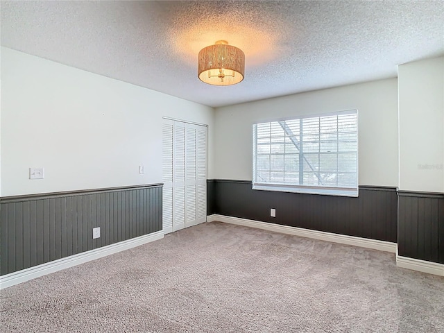 empty room with carpet flooring and a textured ceiling