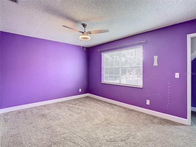 carpeted empty room featuring ceiling fan and a textured ceiling