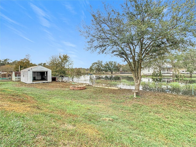 view of yard featuring a water view and an outdoor structure