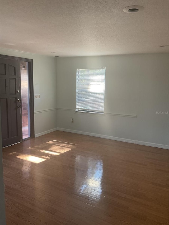 unfurnished room featuring a textured ceiling and dark wood-type flooring