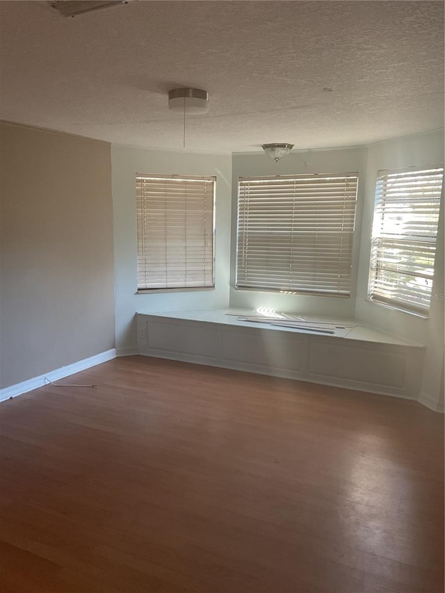 spare room featuring hardwood / wood-style floors and a textured ceiling