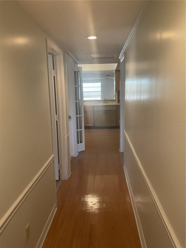 corridor with dark hardwood / wood-style floors and sink