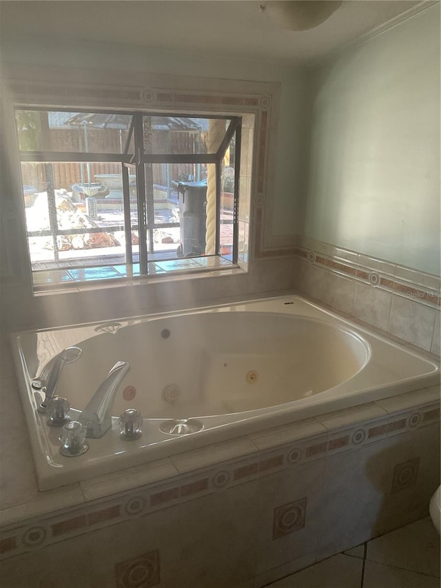 bathroom with tile patterned flooring, plenty of natural light, and tiled bath