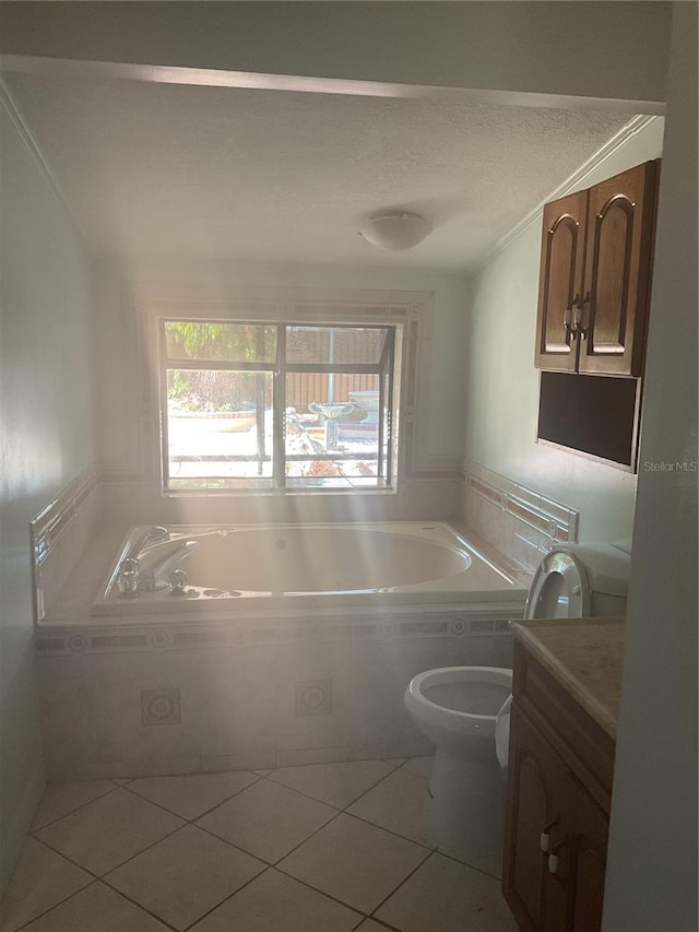 bathroom with tile patterned floors, a tub to relax in, vanity, and toilet