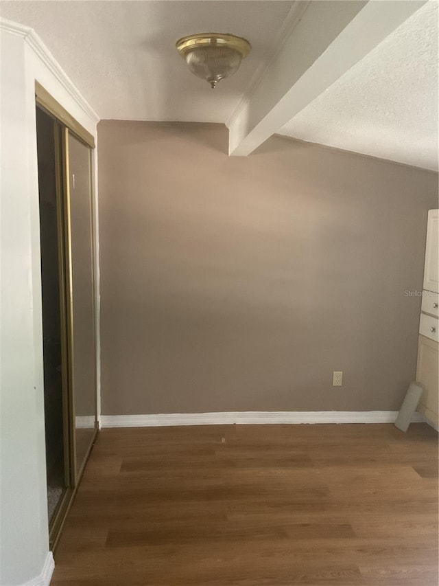 hallway featuring beam ceiling, crown molding, and dark hardwood / wood-style floors