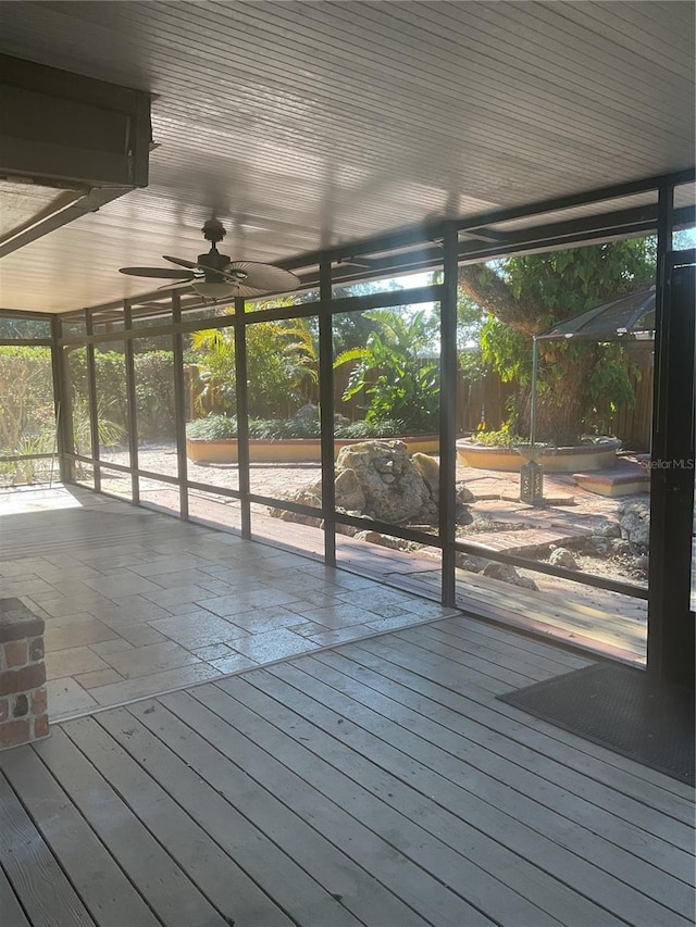 unfurnished sunroom featuring ceiling fan