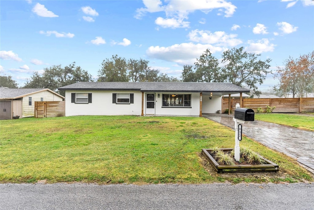 ranch-style home with a front yard and a carport