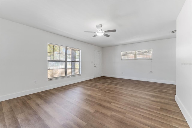 unfurnished room with hardwood / wood-style floors, a wealth of natural light, and ceiling fan