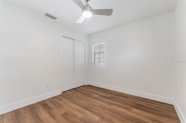 unfurnished bedroom with hardwood / wood-style flooring, ceiling fan, and a closet