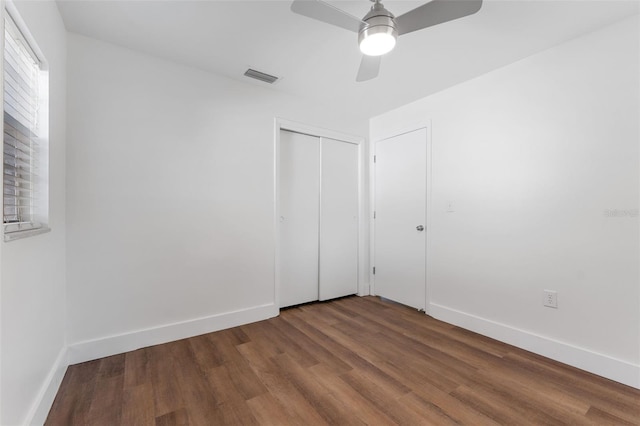 unfurnished bedroom featuring wood-type flooring, ceiling fan, and a closet