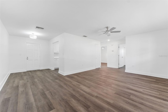 unfurnished living room featuring dark wood-type flooring and ceiling fan