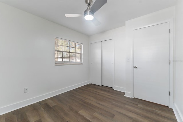 unfurnished bedroom with dark wood-type flooring, a closet, and ceiling fan