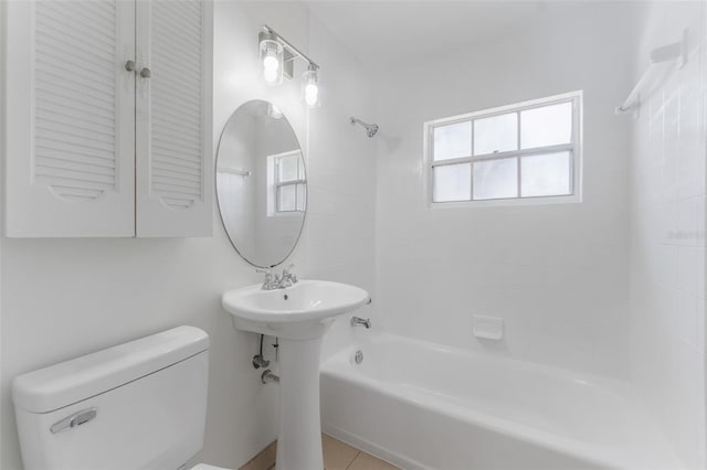 bathroom featuring tiled shower / bath combo and toilet