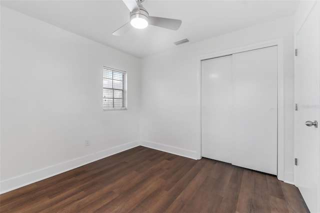 unfurnished bedroom featuring ceiling fan, dark hardwood / wood-style flooring, and a closet